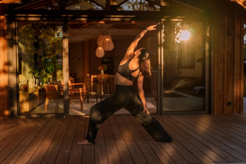 Posture d'étirement de Pilates pratiquée en extérieur par Virginie Hampl